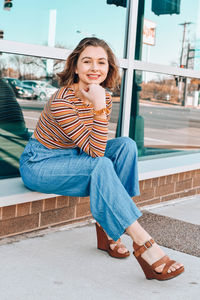 Portrait of smiling young woman sitting outdoors