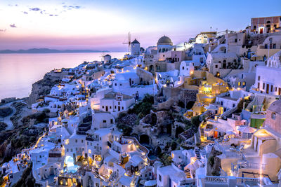 Houses by sea against sky during sunset at santorini