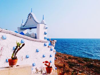 Built structure by sea against clear sky