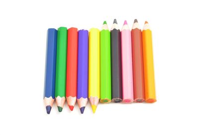 High angle view of colored pencils against white background