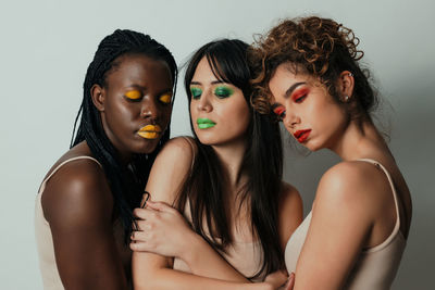 Close-up of women standing against white background