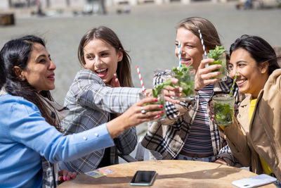 Friends toasting wineglasses while sitting at restaurant