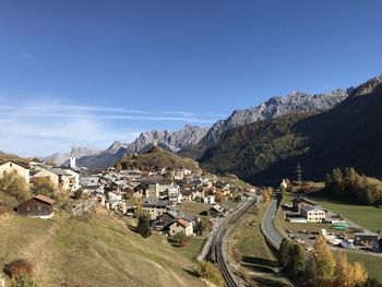 Panoramic view of buildings and mountains against blue sky