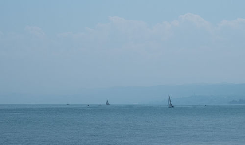 Sailboat in sea against sky
