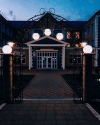 Illuminated street light by building at night