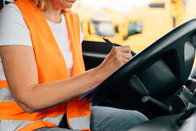 Midsection of man using mobile phone while sitting in car