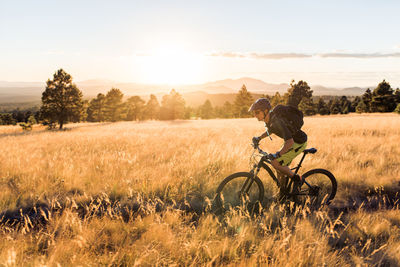 Male mountain biker riding along arizonal trail at sunset