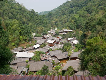 High angle view of houses amidst trees and buildings