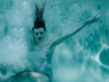 Portrait of young woman swimming in pool