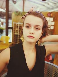 Close-up portrait of young woman sitting in restaurant