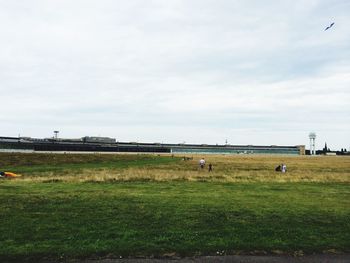 View of grassy field against cloudy sky