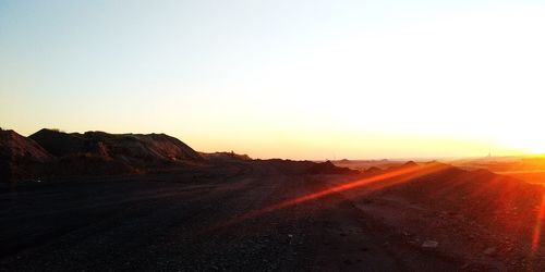 Scenic view of landscape against clear sky during sunset