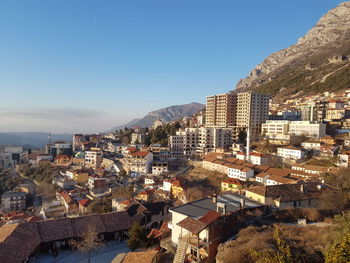 Buildings in city against clear blue sky