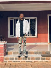 Portrait of young man standing against wall