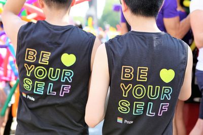 Rear view of men wearing black text t-shirts