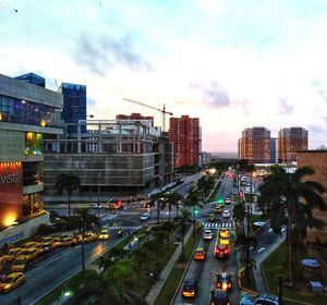 Traffic on road amidst buildings in city against sky