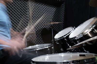 Blurred motion of drummer playing music at concert