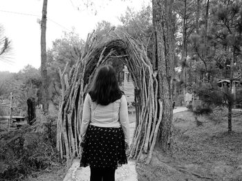 Rear view of woman standing amidst trees