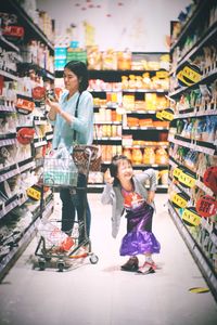 Full length of woman having food in store