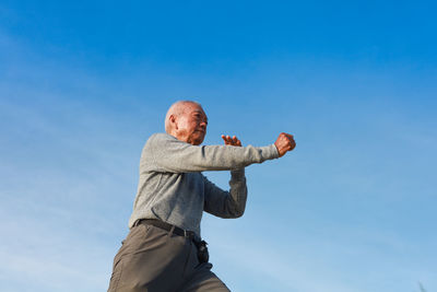 Low angle view of man with blue sky