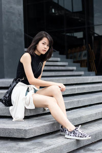 Portrait of woman sitting on staircase