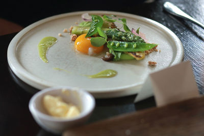 High angle view of egg yolk with vegetables served in plate