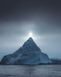 Scenic view of snowcapped mountain against sky at night