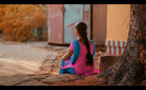 Rear view of woman standing against wall