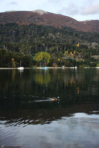 Scenic view of lake by mountain against sky