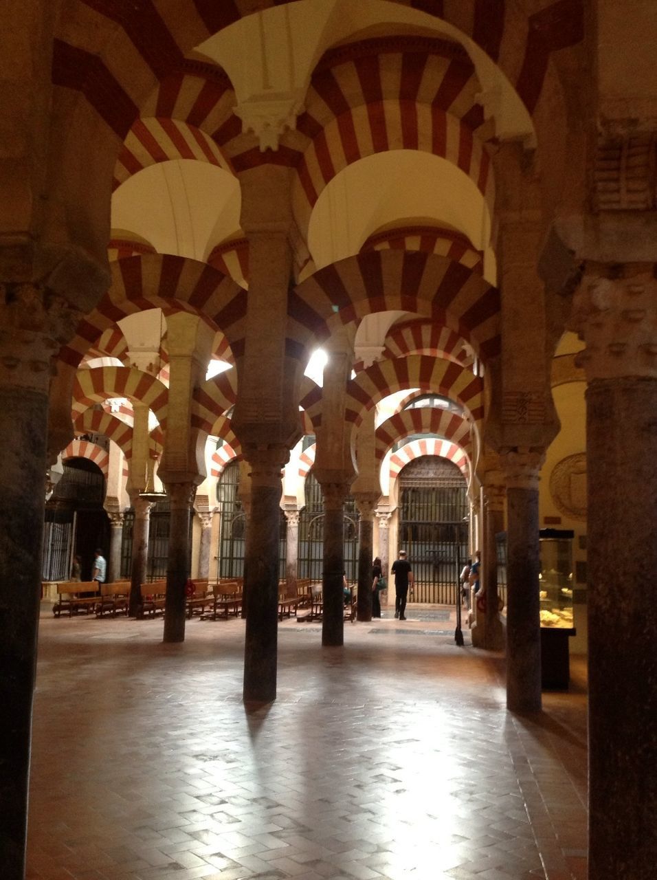 arch, architecture, built structure, indoors, architectural column, corridor, column, history, illuminated, building exterior, archway, colonnade, building, flooring, arched, travel destinations, statue, historic, famous place, incidental people