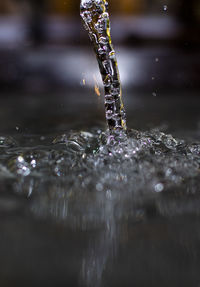 Close-up of drop falling on water