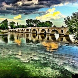 Scenic view of river against cloudy sky