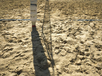 Shadow of volleyball net on sand at beach
