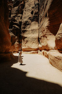 Rear view of man walking on rock