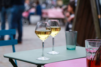 Close-up of wine glasses on table a sidewalk cafe