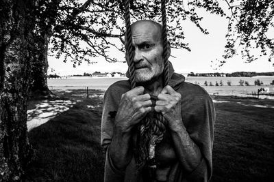 Portrait of man holding ropes while standing outdoors