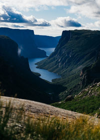 Scenic view of sea and mountains against sky