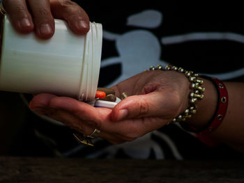 Midsection of person holding pills