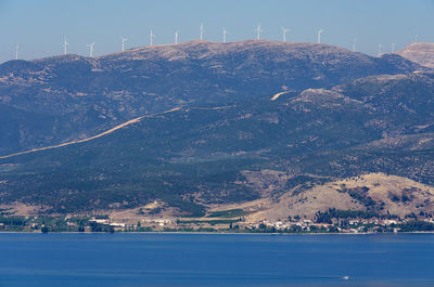 Scenic view of sea by mountains against sky