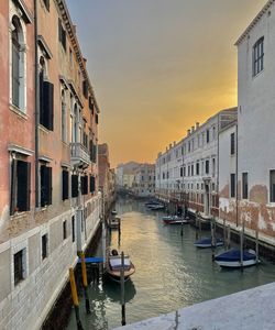 Boats in canal amidst buildings in city