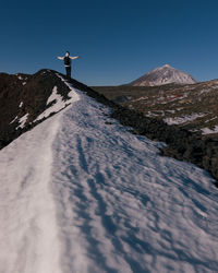 Man on snowcapped mountain against sky