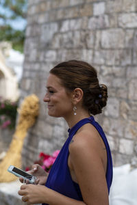 Side view of woman using mobile phone outdoors