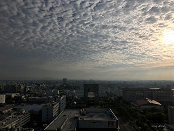 Cloudy sky over cityscape during sunset