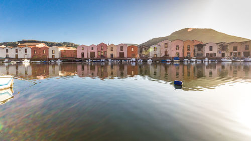 Buildings by lake against clear sky