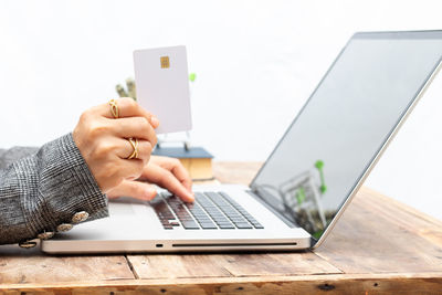 Midsection of man using mobile phone on table