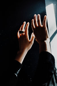 Cropped hands of woman by window