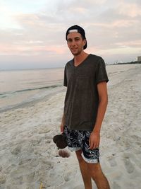 Portrait of young man standing on beach