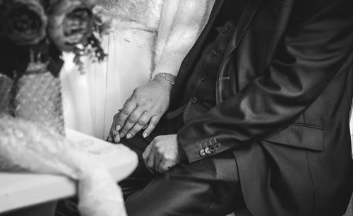 Midsection of couple holding hands