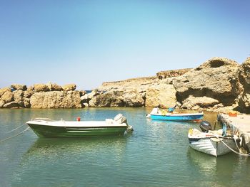 Scenic view of boats moored in water against clear sky