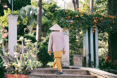 Rear view of man walking steps leading towards park